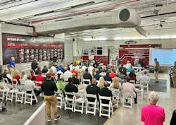 A new pumper destined for Pasco County, FL, Fire Rescue served as a backdrop for the celebration Wednesday. On the wall to the left is a 50-year timeline covering E-ONE&apos;s history.