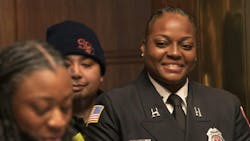 St. Paul Fire Capt. Brittney Baker listens to her daughter, Naaziah Baker, 15, read a St. Paul City Council resolution honoring her mother in St. Paul City Council Chambers on March 27.