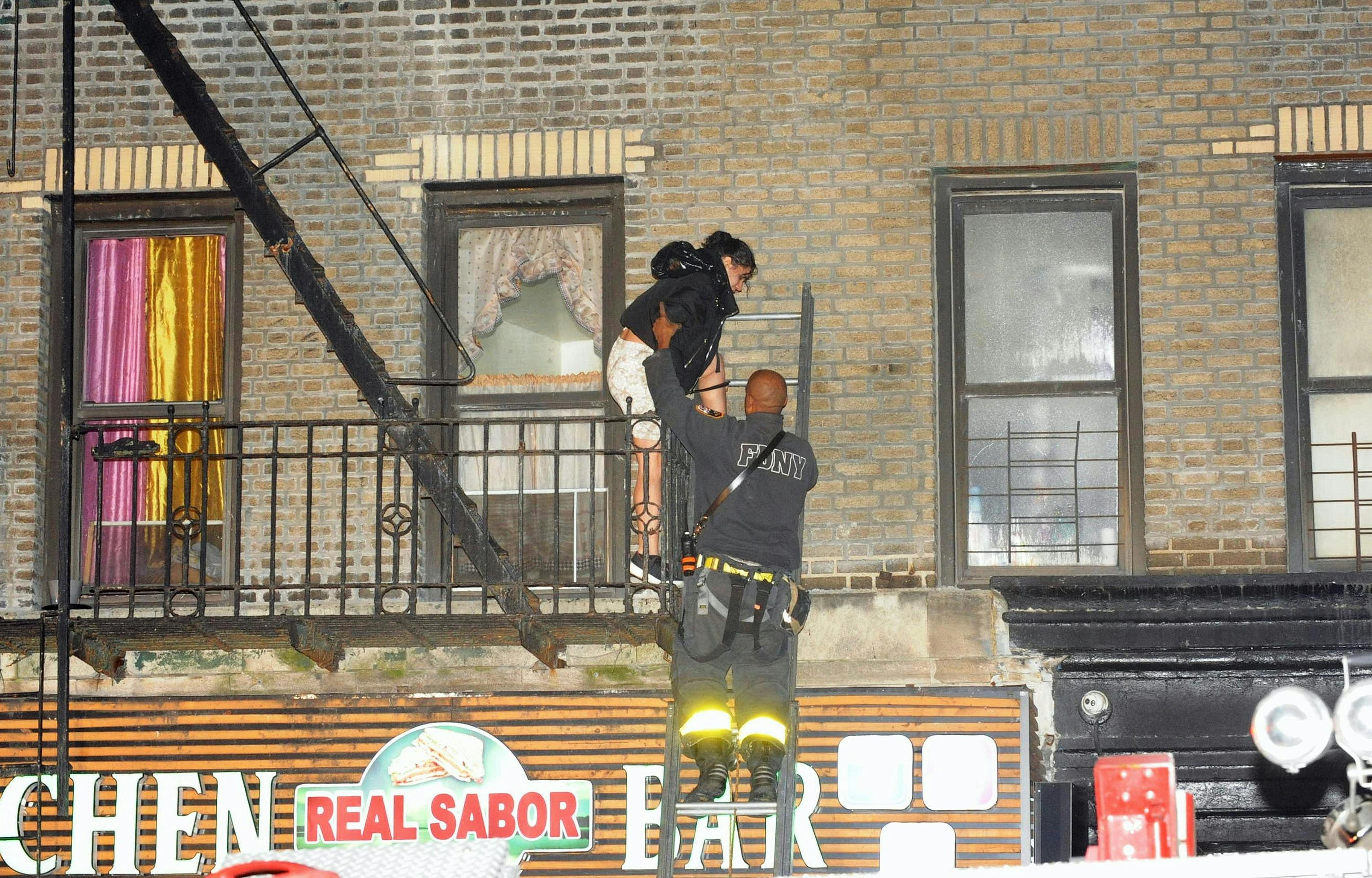 An FDNY firefighter rescues a resident at the March 20 fire where three children were left at home alone.