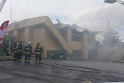 Following the collapse, firefighters shifted to a defensive stance, deploying aerial master streams to direct water into the building through the roof openings.