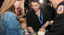 A child listens intently to the words of a fire official while receiving a flag during the National Fallen Firefighters Memorial Service.