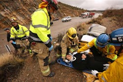San Bernardino County Capt. Dan Tellez, second from left, works with fire crews at an accident scene in the desert. The crew, from Station 53 in Baker, is the only fire crew along the I-15, one of the busiest freeway corridors in the country.