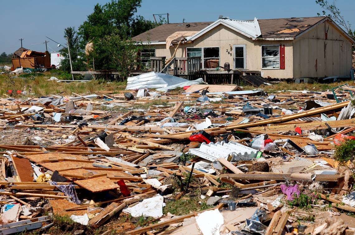 Debris surrounds a home in Valley View, TX, the morning after severe storms moved through Denton and Cooke counties Saturday night.