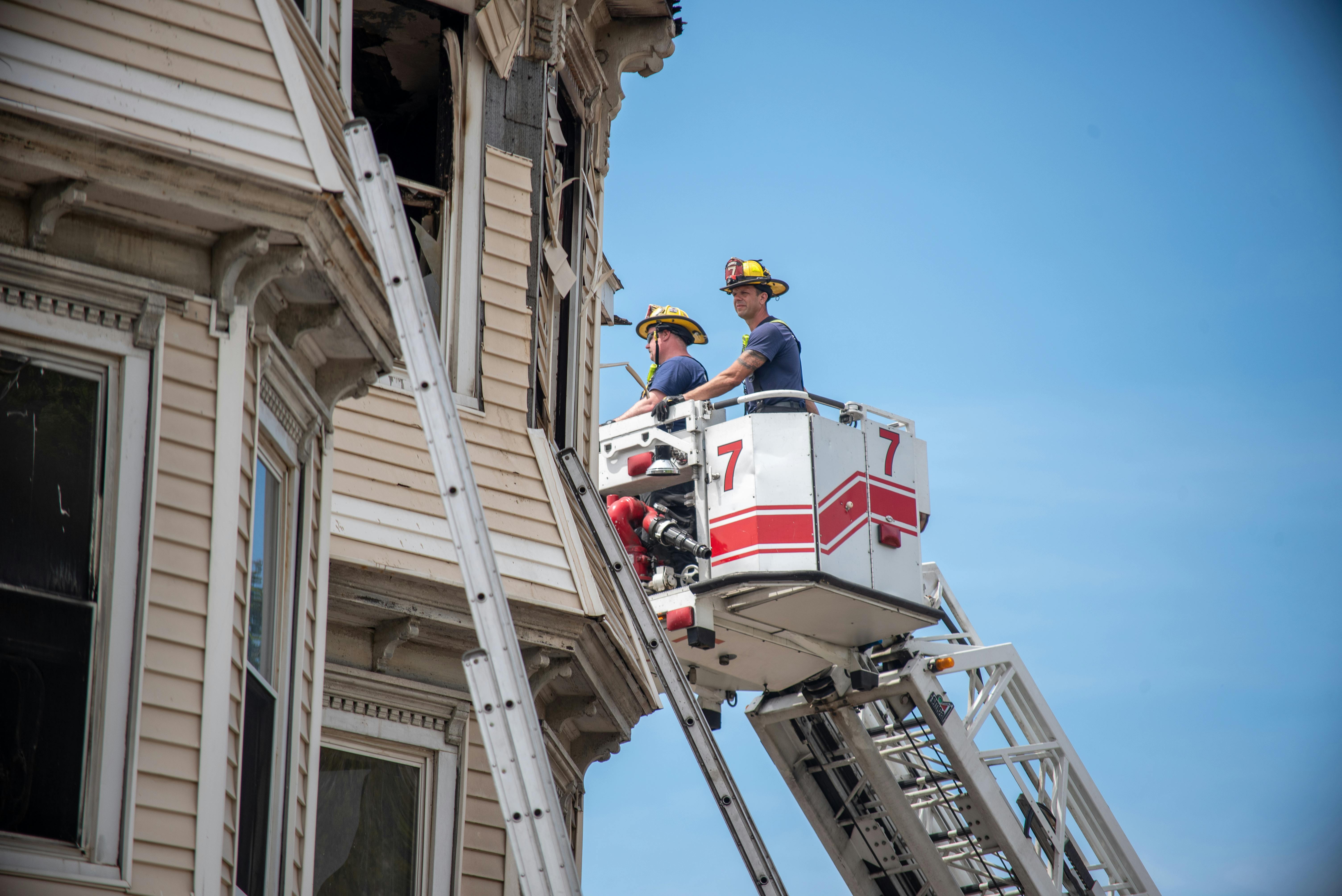 Firefighters working at triple-decker fire.