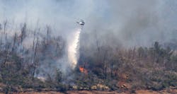 A helicopter drops water over the Thompson Fire near the Oroville Dam on Wednesday.