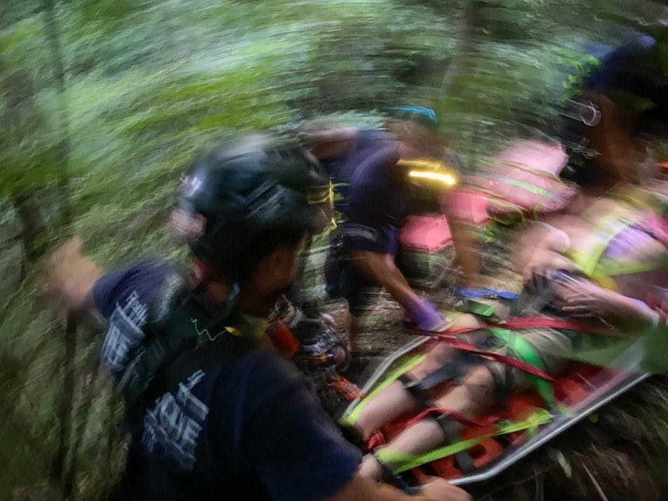 A patient who fell down an embankment is carried up a steep embankment by Frederick County fire and rescue personnel.