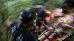 A patient who fell down an embankment is carried up a steep embankment by Frederick County fire and rescue personnel.