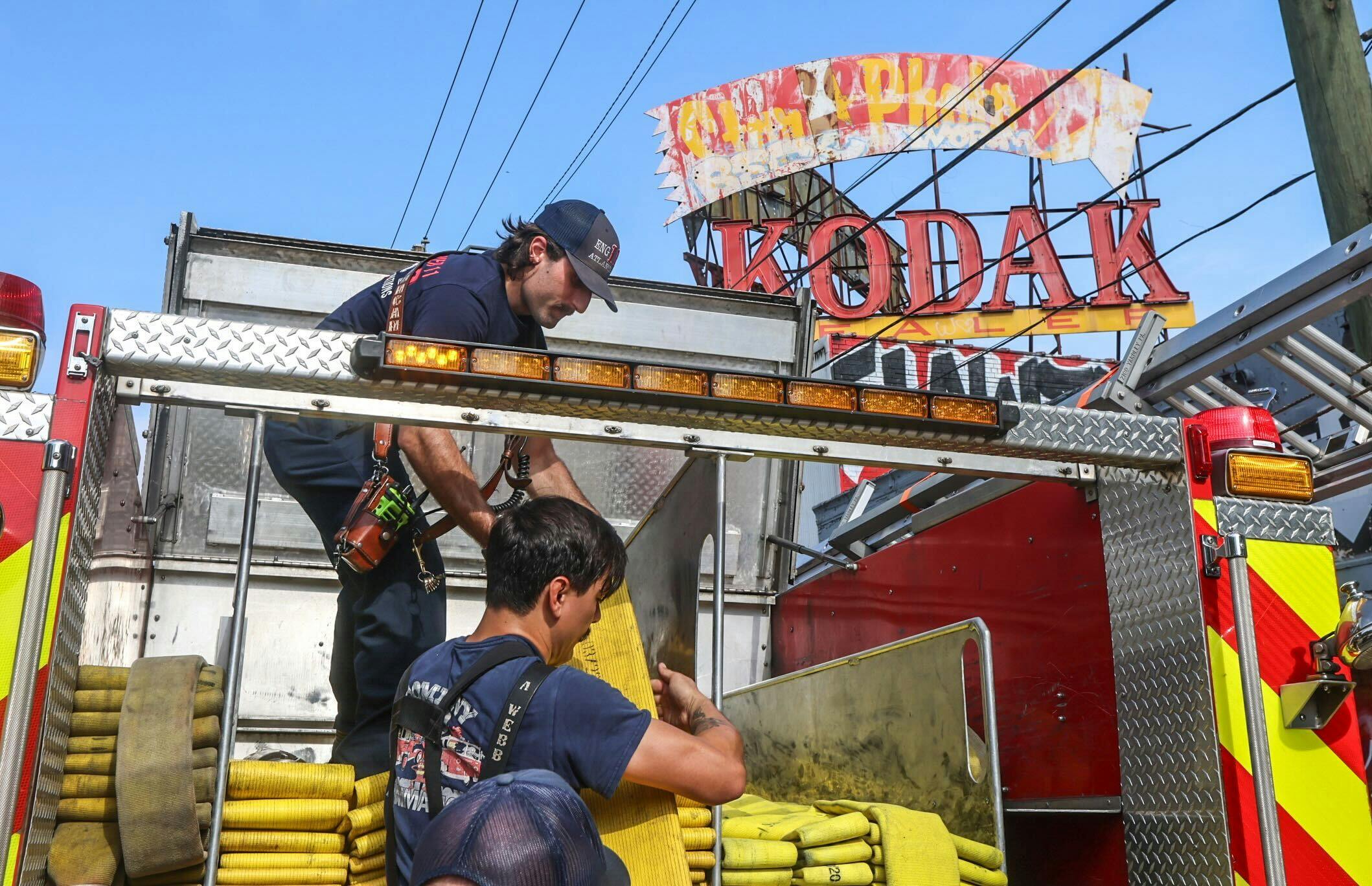 Atlanta firefighters pack up hose after a building fire.