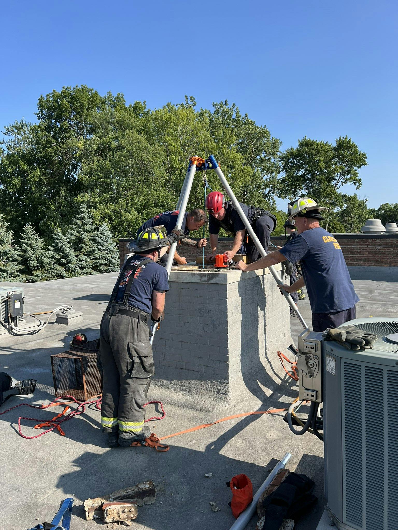 Cleveland firefighters prepare to extricate a man stuck in a chimney.