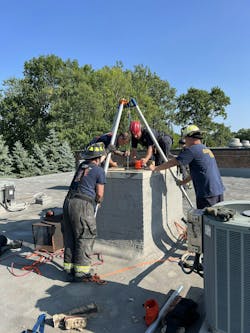 Cleveland firefighters prepare to extricate a man stuck in a chimney. Cleveland firefighters prepare to extricate a man stuck in a chimney.