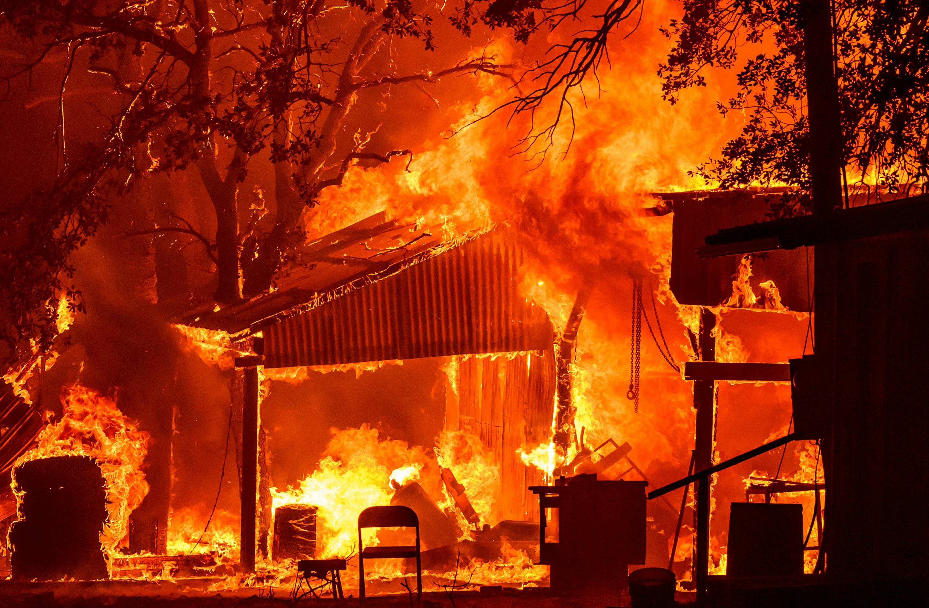 A home near Paynes Creek in Tehama County burns early during the Park Fire.