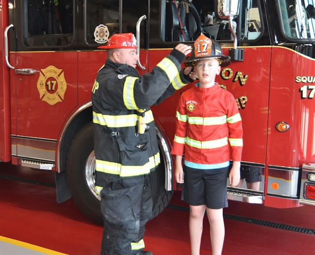 Jaxon Aldridge and Firefighter Sean Joyce of the Aston Township, PA, Fire Department’s (ATFD) exchange hats as they talk about what real firefighters wear.
