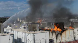 Firefighters apply water as fire burns through a lithium battery storage container at the San Diego Gas and Electric N.E. Operations Center in Escondido.