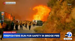 Firefighters run from flames as wildfire advances in Angeles National Forest