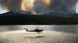 A helicopter fills up to drop water on the Alexander Mountain fire burning west of Loveland on Monday, July 29, 2024.