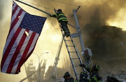 FDNY Capt. Michael Dugan hangs a flag from a light pole in front of what is left of the World Trade Center after it was destroyed in a terrorist attack. FDNY Capt. Michael Dugan hangs a flag from a light pole in front of what is left of the World Trade Center after it was destroyed in a terrorist attack.