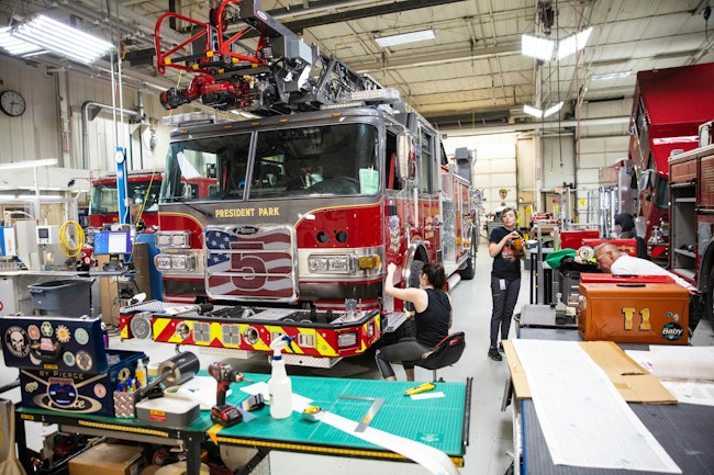 Pierce employees work on an aerial ladder in the factory.