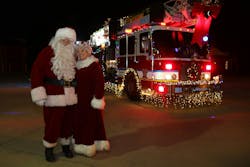 Mr. and Mrs. Claus pose in front of the lit up Zoneton, KY, Fire Protection District fire apparatus. Mr. and Mrs. Claus pose in front of the lit up Zoneton, KY, Fire Protection District fire apparatus.