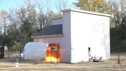 Figure 3. As a result of an explosion of the gas that could be generated by a battery pack that contains 100 NCA 18650 cells, the overhead door of a test-site garage landed 50 feet away from the structure. Figure 3. As a result of an explosion of the gas that could be generated by a battery pack that contains 100 NCA 18650 cells, the overhead door of a test-site garage landed 50 feet away from the structure.