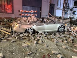 Two cars parked outside the building were damaged when the structure collapsed. Two cars parked outside the building were damaged when the structure collapsed.
