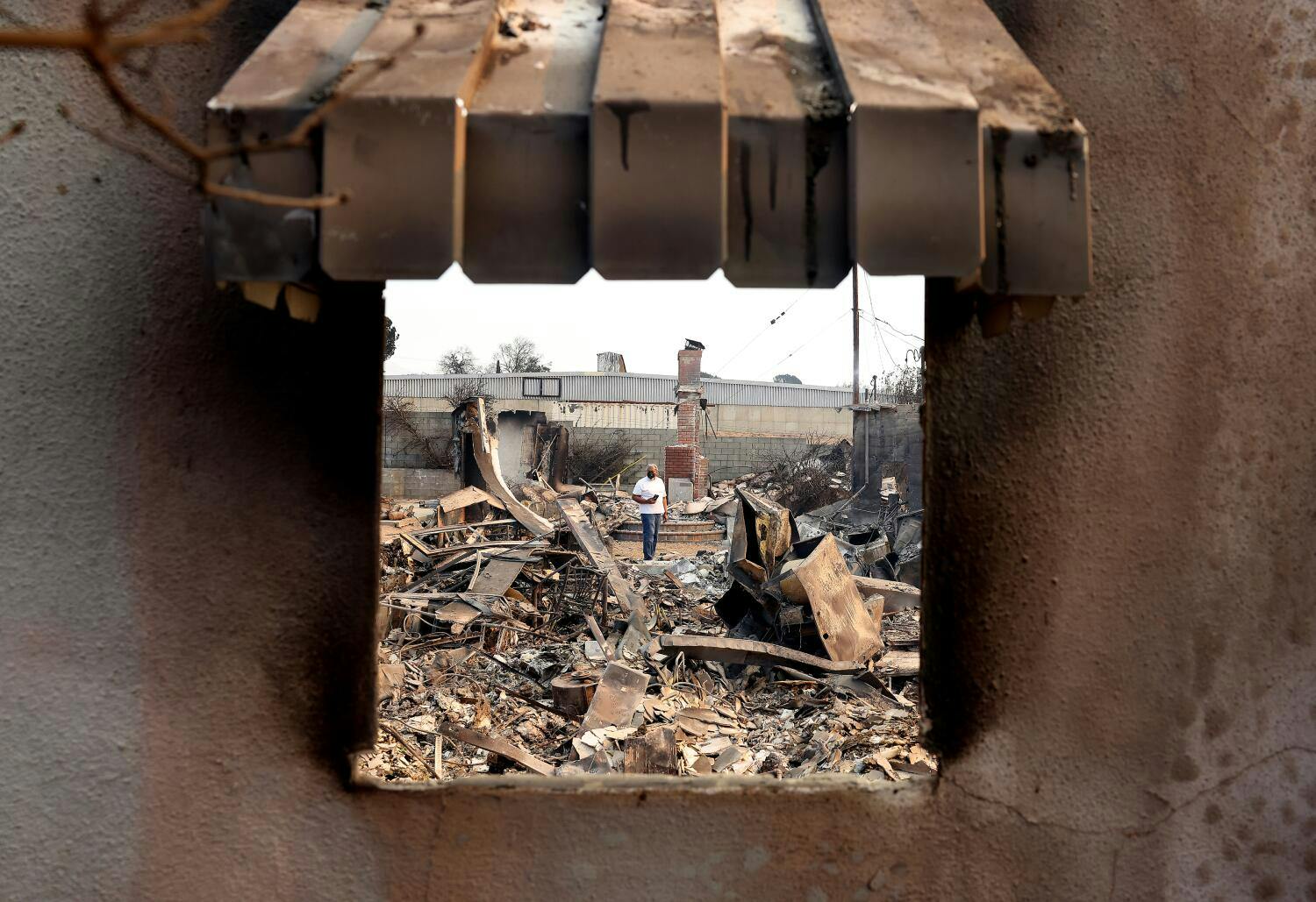 William Harris looks over the damage to a home ravaged by the Eaton Fire in Altadena on Thursday.