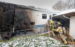 Fort Worth firefighters work to gain access to the interior of the RV while a firefighter douses the fire. Fort Worth firefighters work to gain access to the interior of the RV while a firefighter douses the fire.