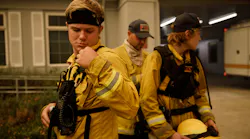 Volunteer firefighter for the Boulder Creek Fire District Jaden Keil-Ribera, 19, left, checks his radio as he waits in front of the fire station before he and other volunteer firefighters in 2020.