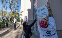 Workers put up a sign as wildfire victims seek disaster relief services at one of two FEMA Disaster Recovery Centers in Pasadena. Workers put up a sign as wildfire victims seek disaster relief services at one of two FEMA Disaster Recovery Centers in Pasadena.
