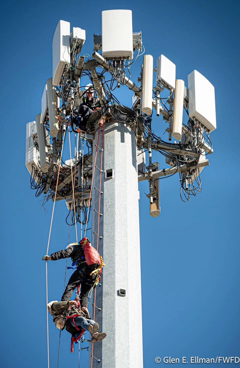 A firefighters gains access to one of the workers who was injured and trapped on the tower.