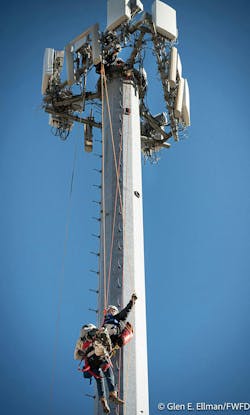 A firefighter is lowered from the tower, along with an injured worker. A firefighter is lowered from the tower, along with an injured worker.