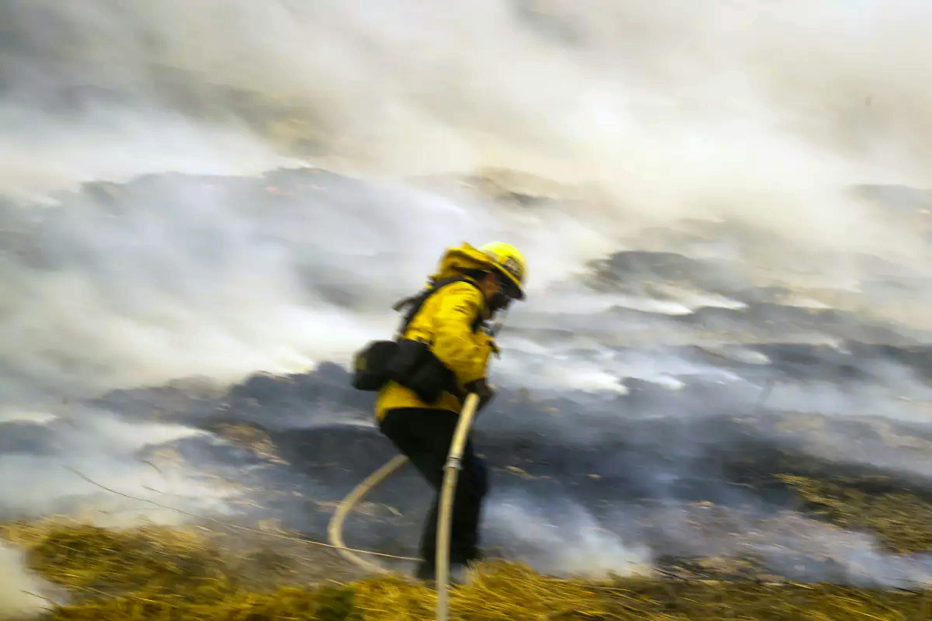 A firefighter climbs a hill to confront flames from the Creek fire in December 2017.