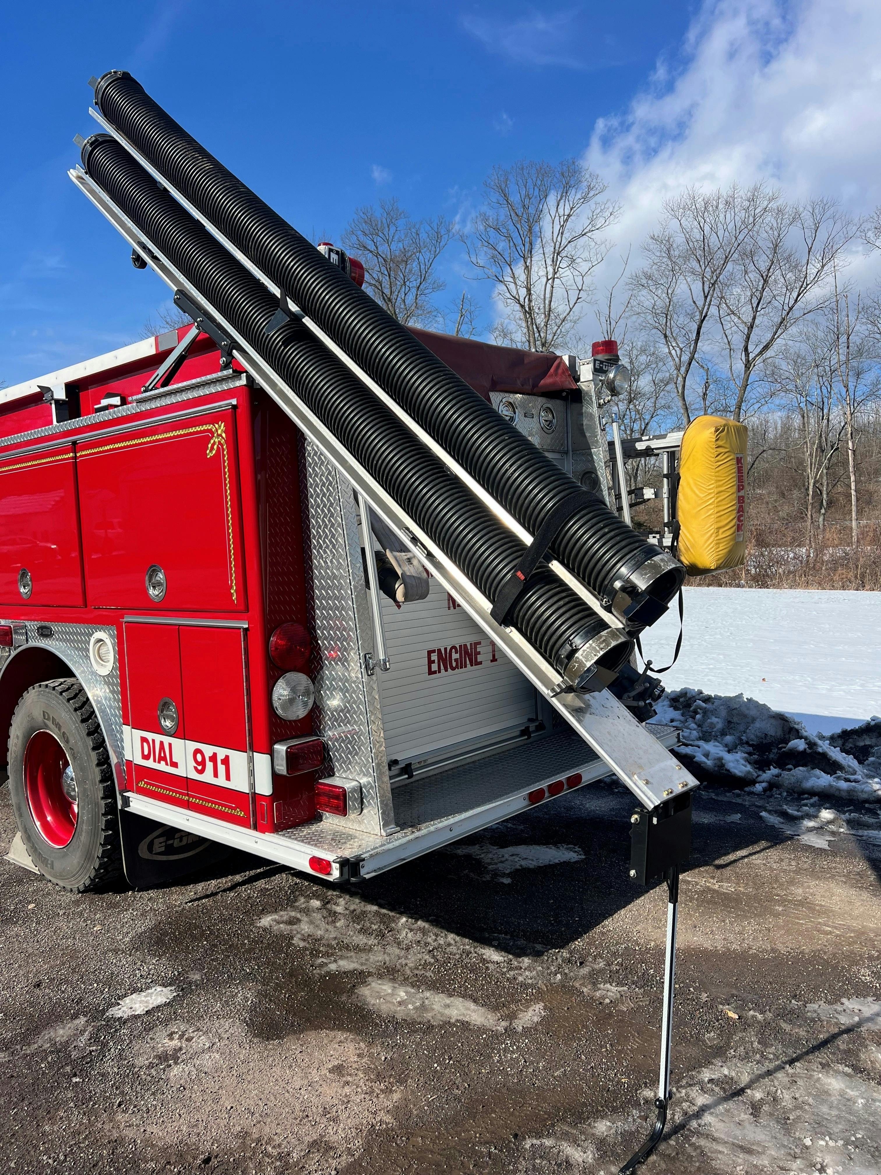 Once the Double Hard Sleeve Gantry is slid to the rear of the apparatus and then tilted upward at an approximate 45-degree angle, the hook and loop straps are released to access the sections of hard sleeve for deployment.