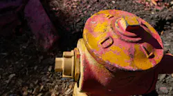 A fire hydrant in Mandeville Canyon in Los Angeles is coated in fire retardant during the January 2025 wildfires. Officials said the Los Angeles Fire Department did not report nearly 1,000 damaged hydrants for months.