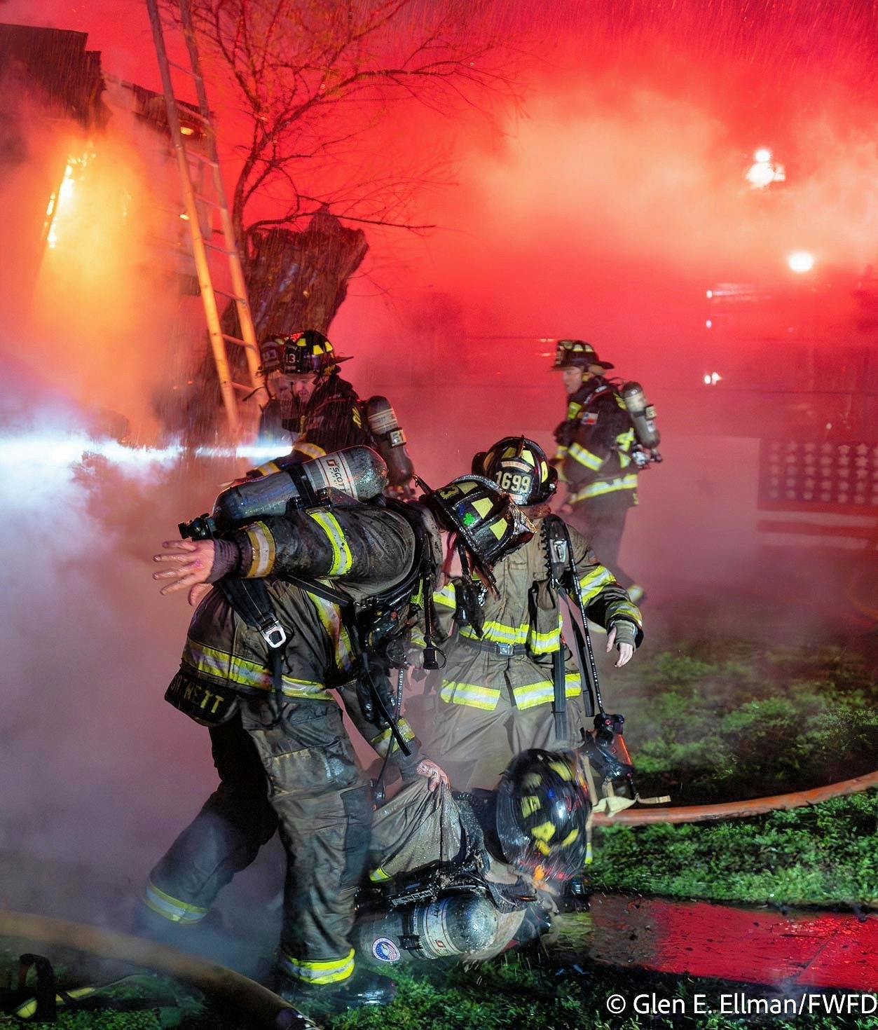 Fort Worth firefighters pull an injured firefighter from the collapse debris.