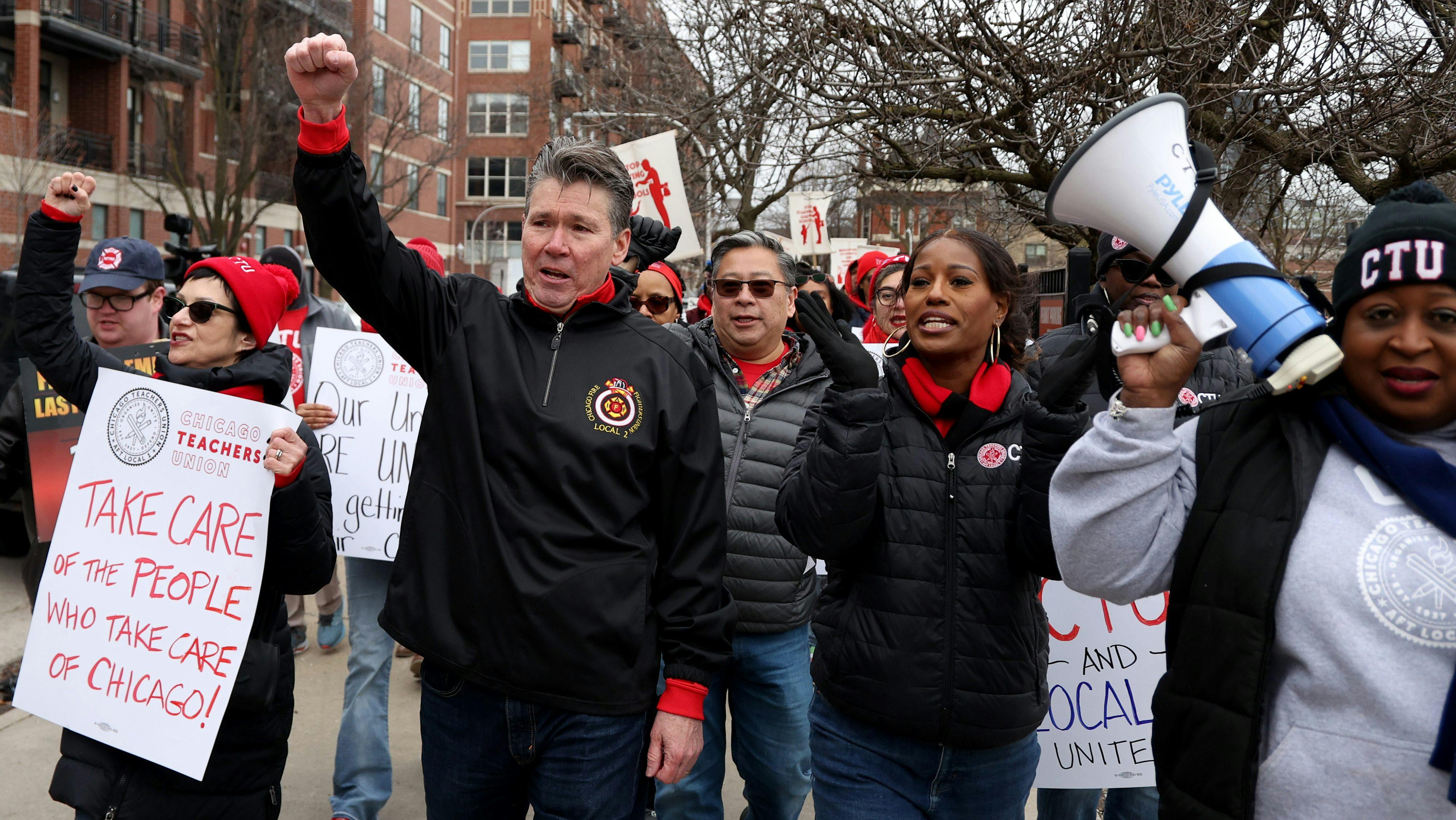 Chicago Firefighters Local 2 President Pat Cleary and Chicago Teachers Union President Stacy Davis Gates march toward Whitney Young High School as dozens of teacher and firefighter union members join forces for fair contracts on March 24, 2025, in Chicago.