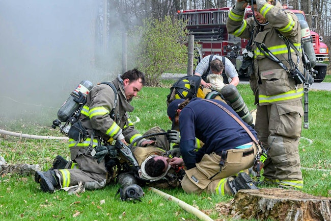 EMTs treat a Convoy firefighter injured at a house fire.