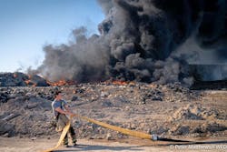 A firefighters positions a large-diameter hose as crews attempt to establish a water supply at the Fort Worth fire. A firefighters positions a large-diameter hose as crews attempt to establish a water supply at the Fort Worth fire.