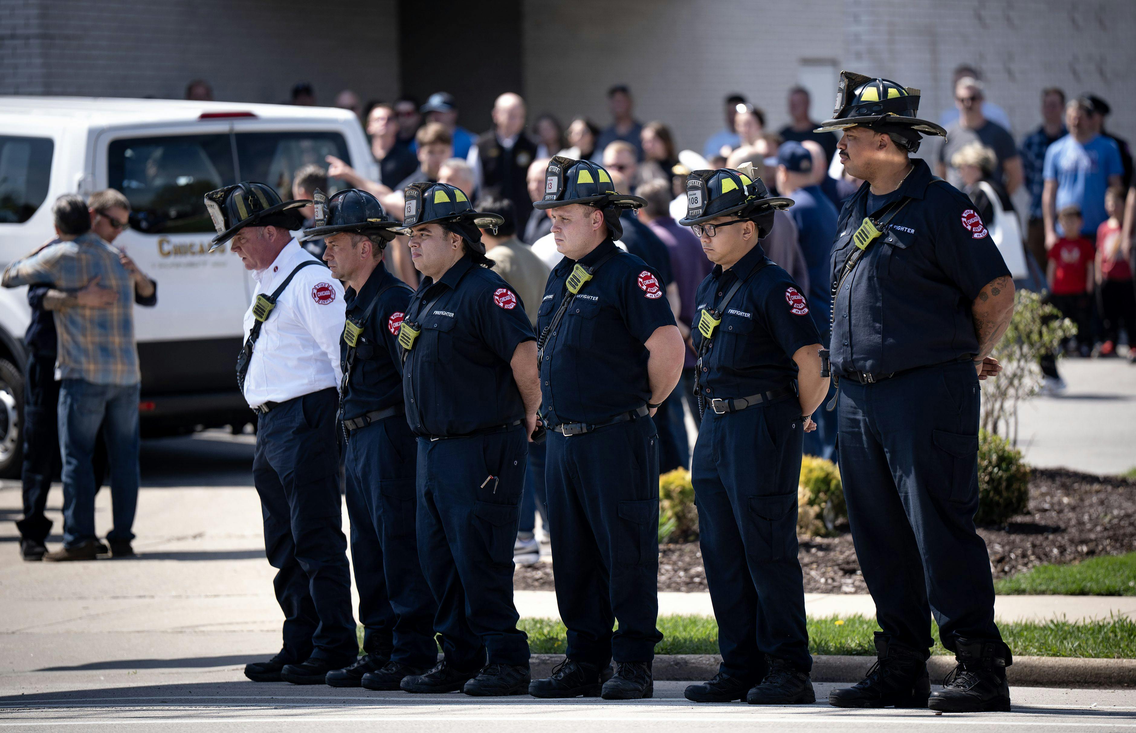 Chicago firefighters wait as an escort arrives with Capt. David Meyer at Malec & Sons Funeral Home.