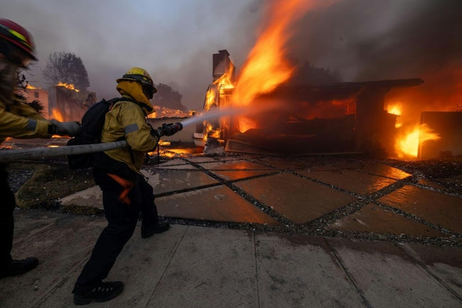 Firefighters battle the Palisades fire on El Medio Ave. on Jan. 7.