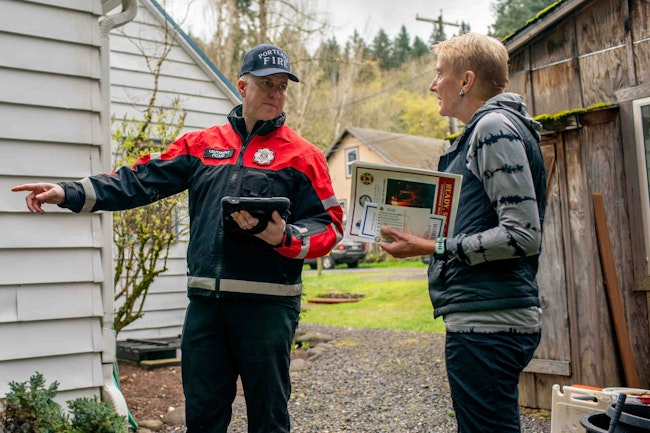Portland Fire & Rescue Lt. Laurent Picard talks with tells property owner Allison Couch during a wildfire home assessment.