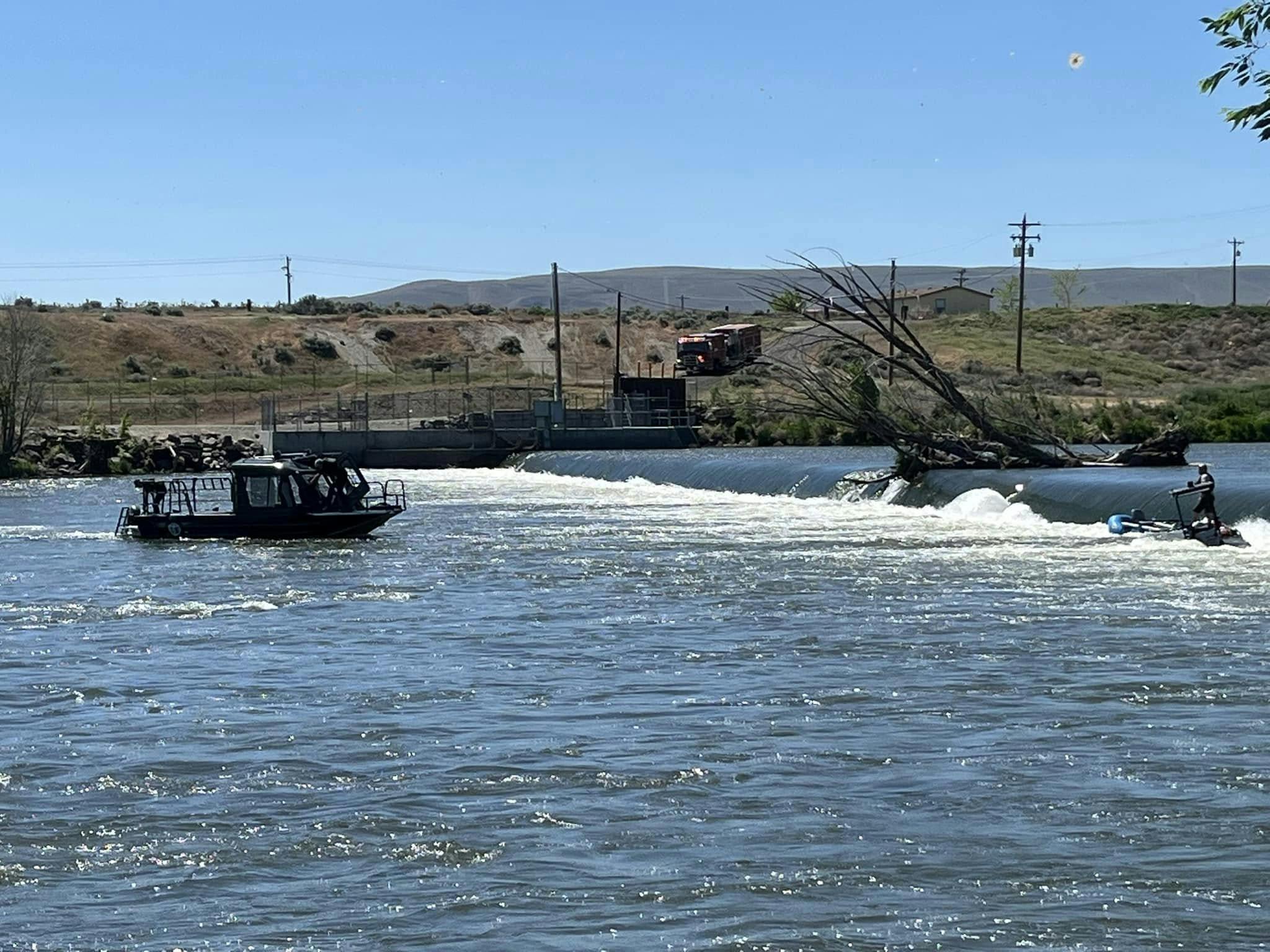 A Benton County firefighter aboard a sinking boat, right, waits to be rescued.