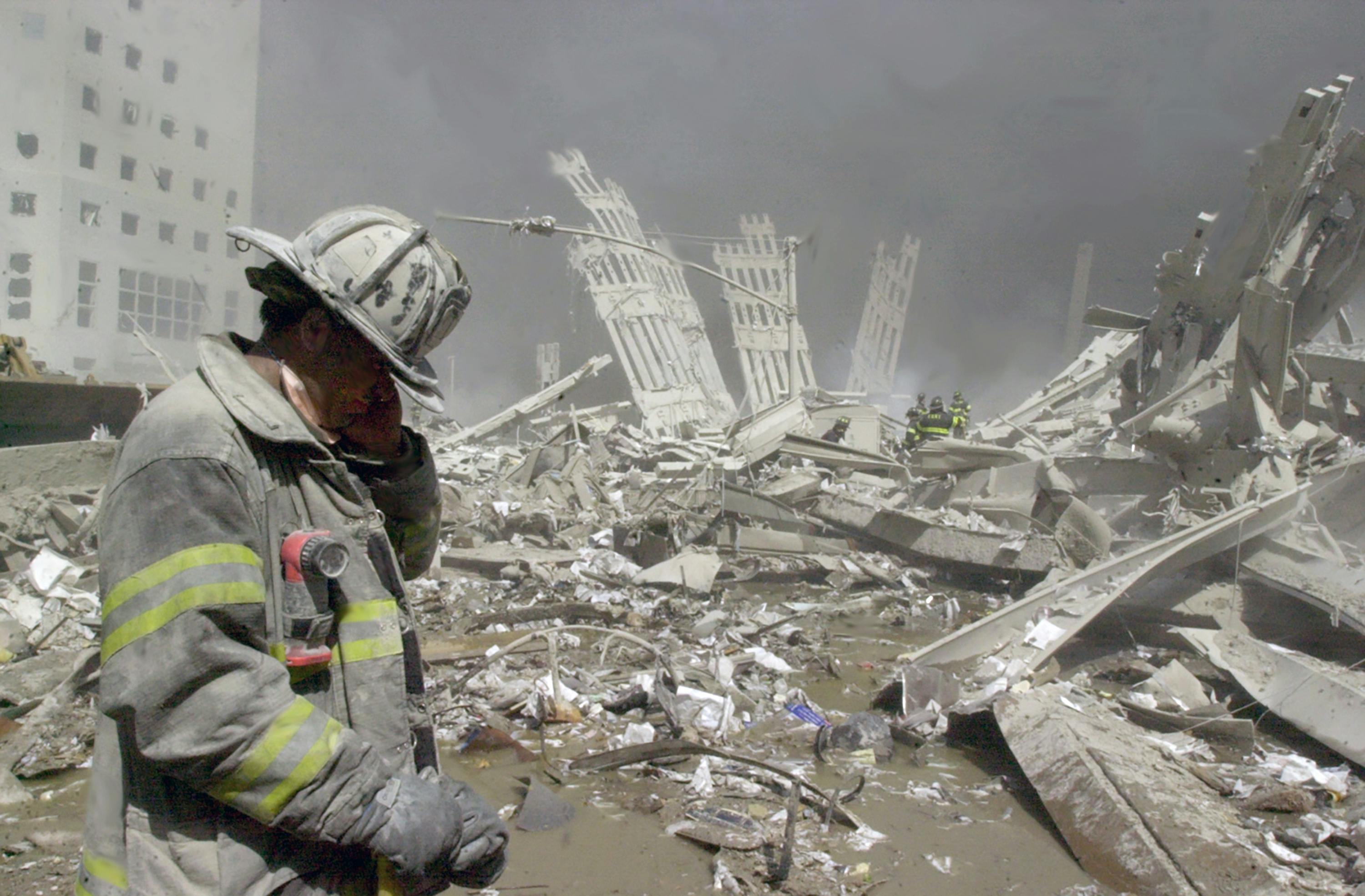 A firefighter stands at the ruins of the World Trade Center.