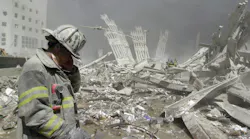 A firefighter stands at the ruins of the World Trade Center.