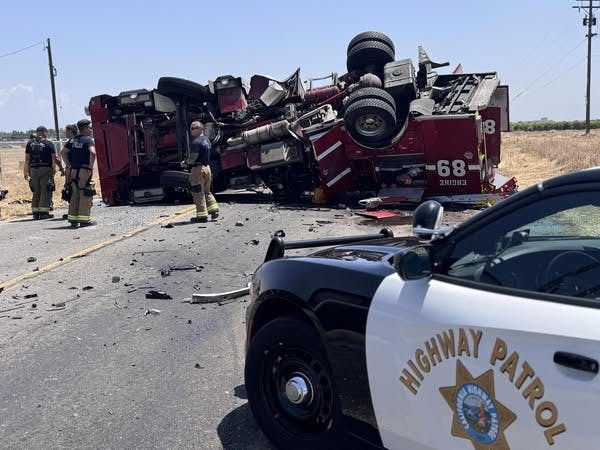 Two firefighters were hurt when their fire truck overturned after a collision.