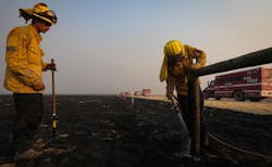 Monterey County firefighters Jonathan Davis, left, and Ryan Cahalan extinguish smoldering wood posts on a cattle fence after the Madre Fire burned through the area on July 3. Monterey County firefighters Jonathan Davis, left, and Ryan Cahalan extinguish smoldering wood posts on a cattle fence after the Madre Fire burned through the area on July 3.