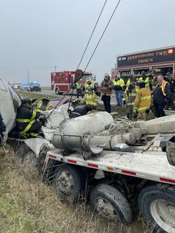 A rescuer (far left) uses hand signals to indicate what he needs the wrecker operator to do. A rescuer (far left) uses hand signals to indicate what he needs the wrecker operator to do.
