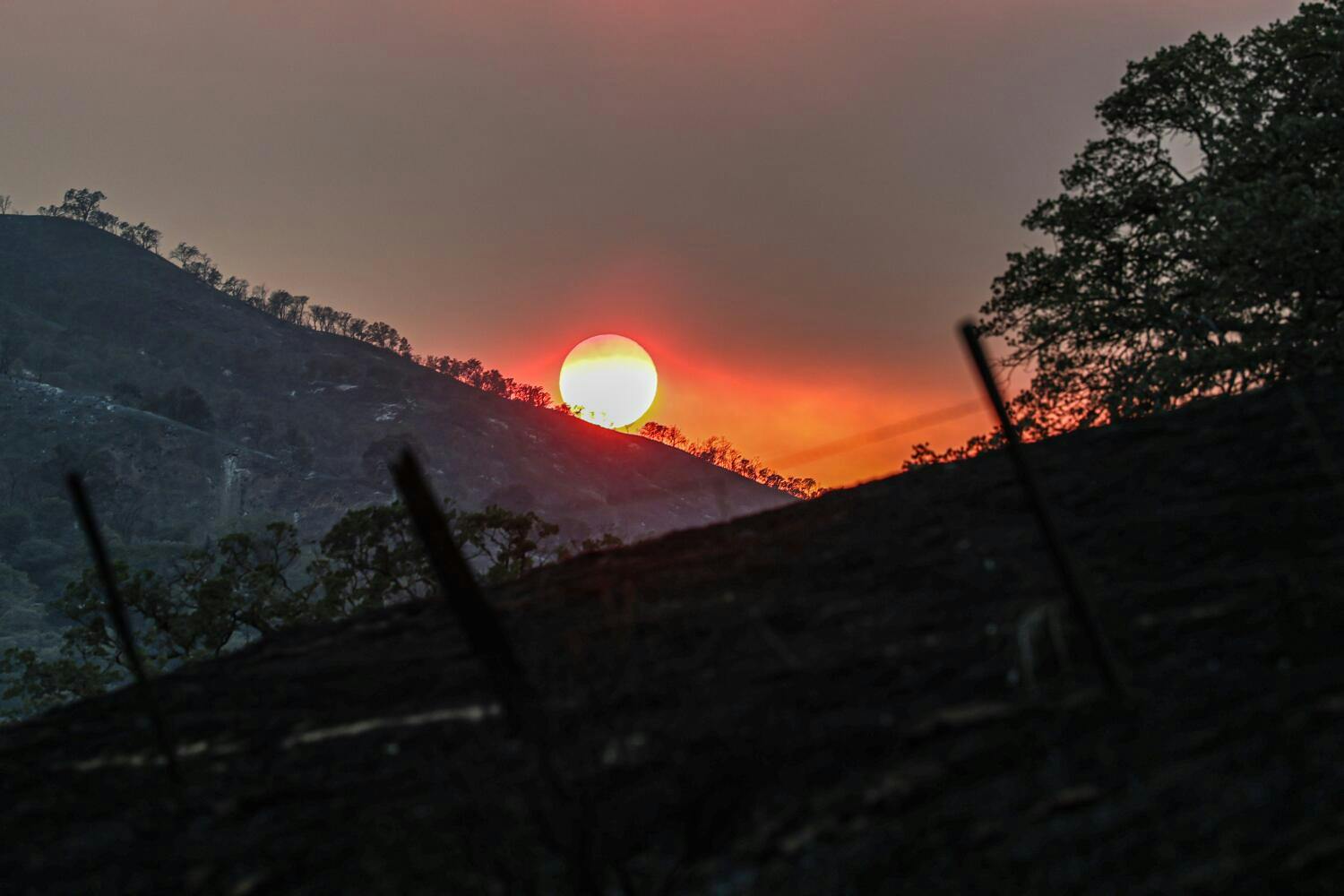 Smoke from the Gifford Fire filters sunlight over the burned hills near the Cuyama Highway.