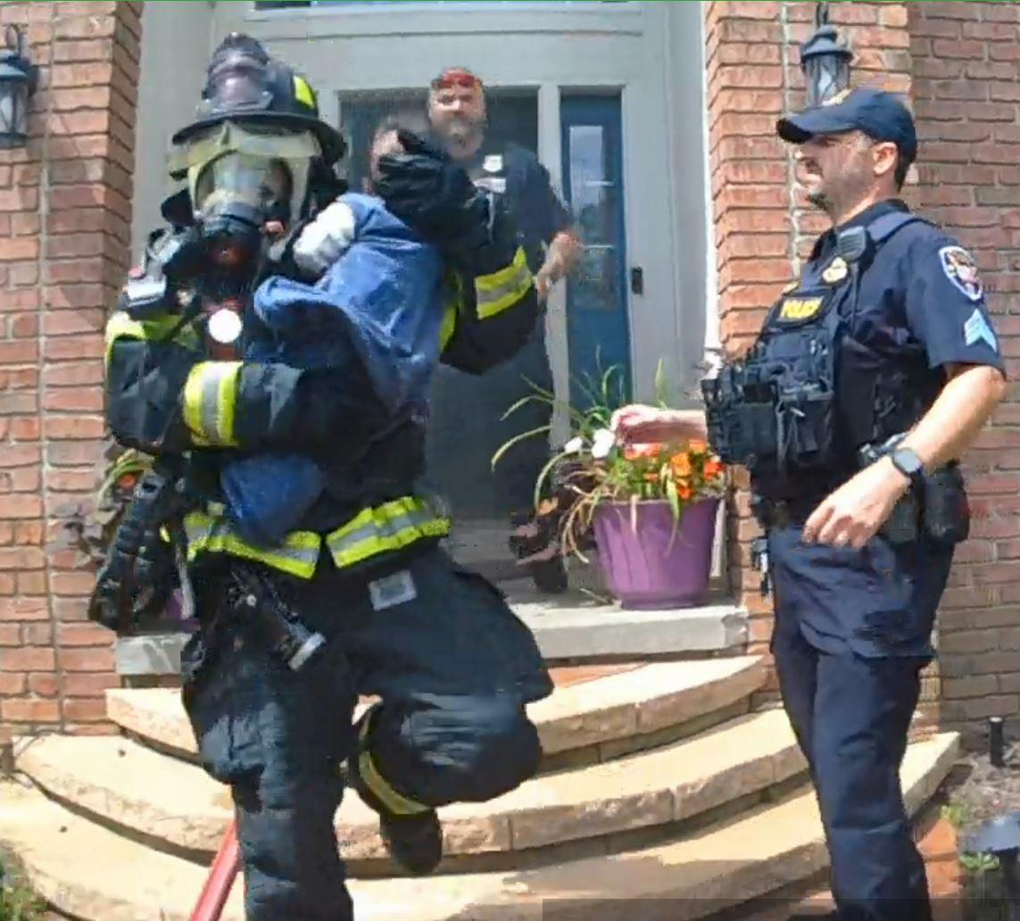 Twinsburg Firefighter Josh Jarzab cradles an eight-month-old boy he and Firefighter Laron Mainor located in a room with a closed door.