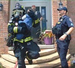 Twinsburg Firefighter Josh Jarzab cradles an eight-month-old boy he and Firefighter Laron Mainor located in a room with a closed door. Twinsburg Firefighter Josh Jarzab cradles an eight-month-old boy he and Firefighter Laron Mainor located in a room with a closed door.