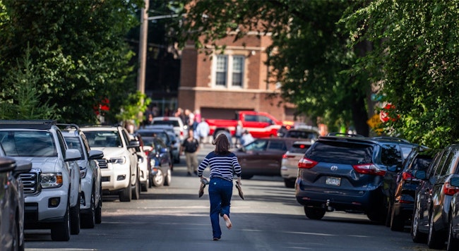A woman runs toward the Annunciation Church in south Minneapolis after a mass shooting Wednesday.
